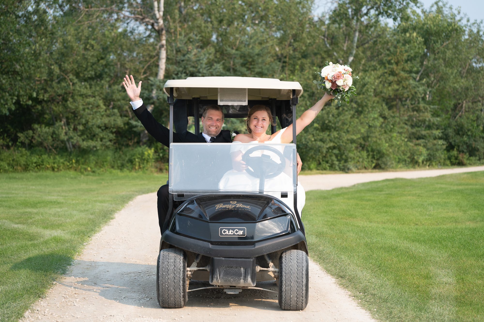 Couple driving a golf cart at Breezy Bend Country Club, Winnipeg